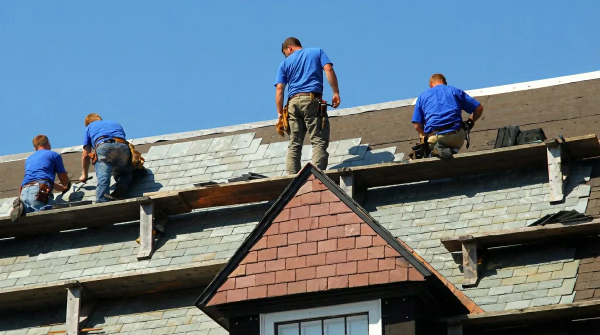 Roof replacement in progress with a team of professional contractors installing new shingles on a residential home in Albuquerque, NM